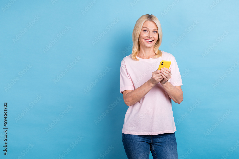 Portrait of cheerful nice lady hold telephone look empty space ad isolated on blue color background