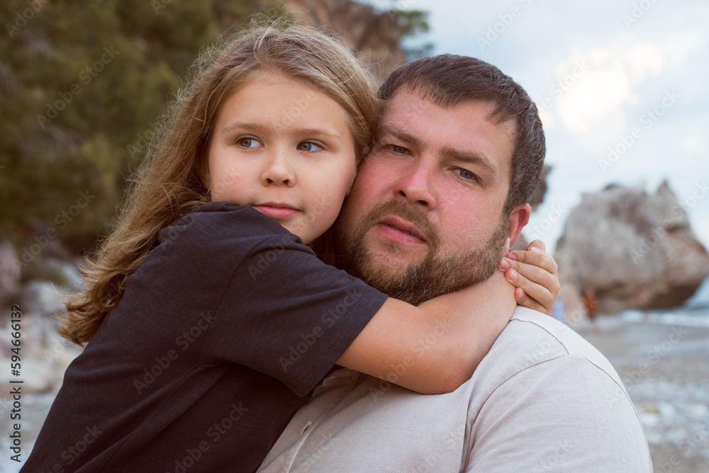 Daughter hugging dad outdoors. walking at the beach, beautiful nature Daughter hugging dad outdoors. walking at the beach, beautiful nature