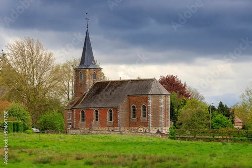 an old church building sitting across from a field of green grass