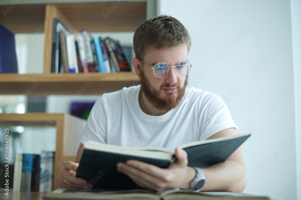 Portrait of serious concentrated guy, young man in glasses college or university student is study hard in library, prepare to exam, lesson Portrait of serious concentrated guy, young man in glasses college or university student is study hard in library, prepare to exam, lesson