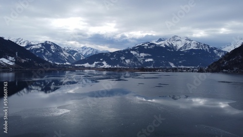 Majestic view of the frozen Zeller lake in Austria with snowy rocky mountains in the background