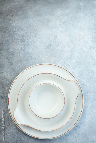 White dinnerware set on the bottomon half dark light gray background with distressed surface