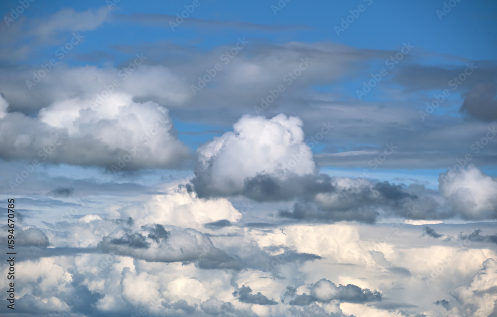 Bright landscape of white puffy cumulus clouds on blue clear sky Bright landscape of white puffy cumulus clouds on blue clear sky