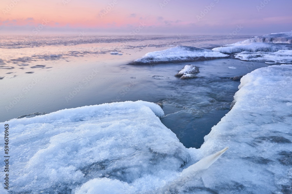 Idyllic frozen rocky shore with pink sky on the horizon, perfect for wallpapers Idyllic frozen rocky shore with pink sky on the horizon, perfect for wallpapers