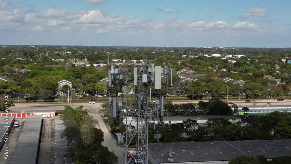 Drone view over a base station tower with a background of an industrial area in Florida Drone view over a base station tower with a background of an industrial area in Florida