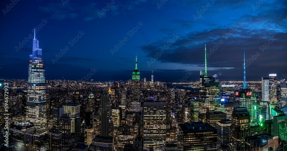 Obraz premium Aerial view of the impressive skyline of New York city at night, illuminated by numerous lights