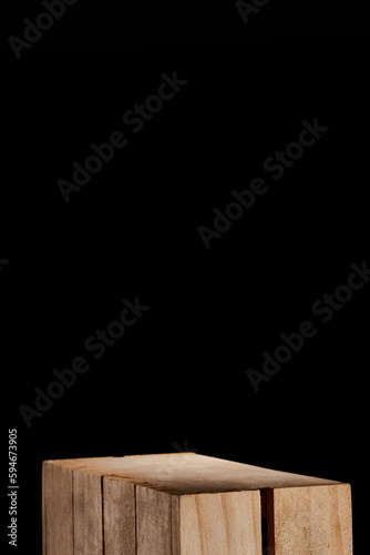 Fototapeta Naklejka Na Ścianę i Meble -  caja de madera clásica en fondo negro como base ideal para exhibir productos cosméticos, alimenticios y otros / classic wooden box on a black background as an ideal base for displaying cosmetic, food 