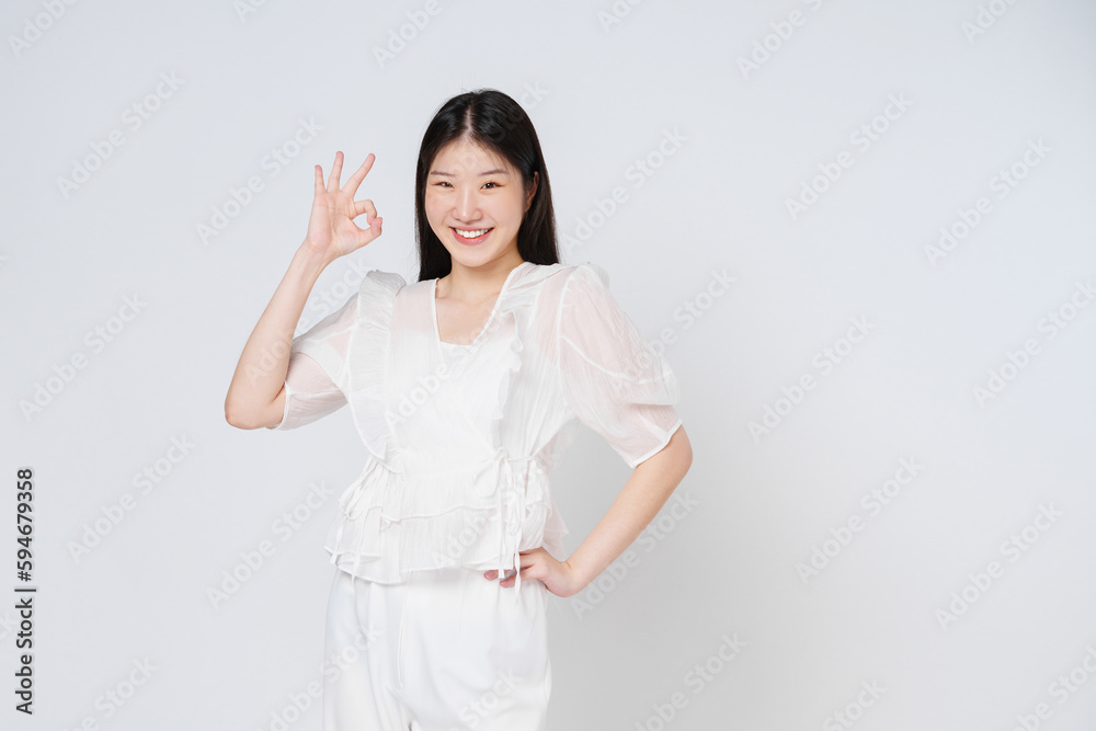 Portrait of young woman smiling and showing ok sign isolated on white background. Portrait of young woman smiling and showing ok sign isolated on white background.