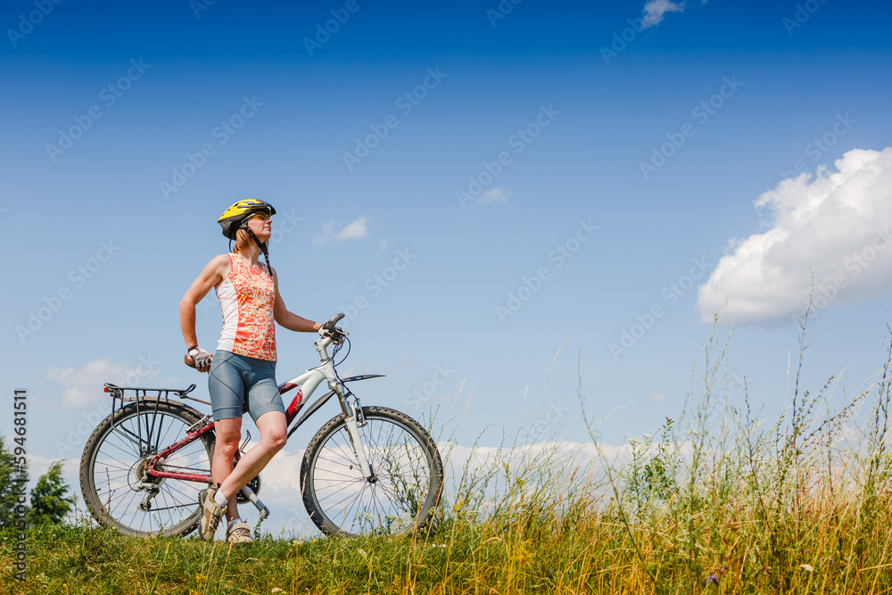 Mountain biking - woman with bike enjoy summer vacation