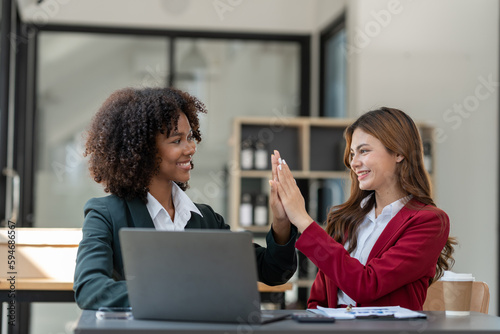 Asian businesswoman and American businesswoman Happy african man clapping with business finance Successful online jobs and achieving goals in the office.
