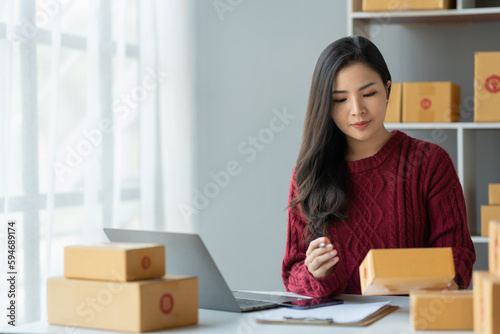 Business woman owner holding parcel box Verify the correctness in the list, address, customer phone number for parcel delivery through the express delivery company. startup business ideas.