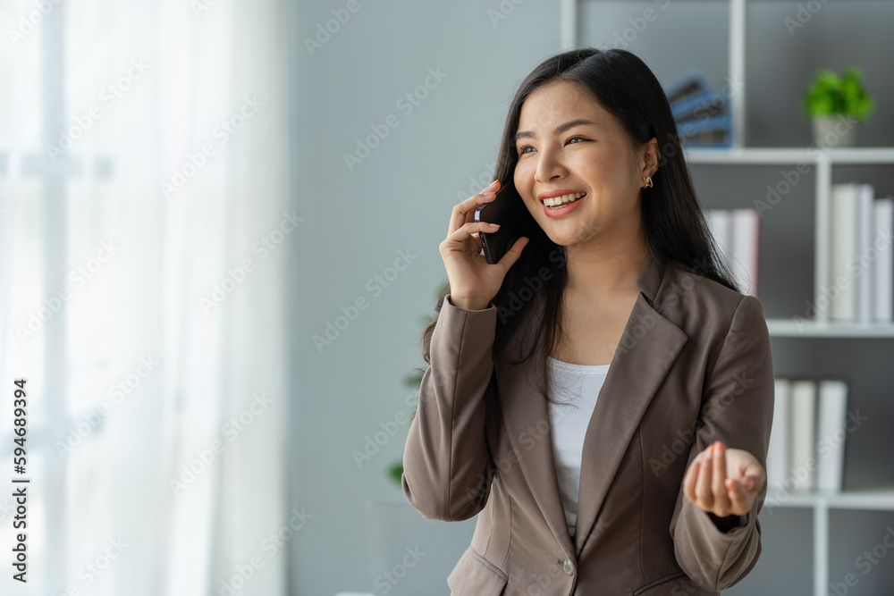 copy space, panorama, banner Asian business woman financially successful entrepreneur professional company executive Wearing a suit standing and talking on the phone in business information. copy space, panorama, banner Asian business woman financially successful entrepreneur professional company executive Wearing a suit standing and talking on the phone in business information.
