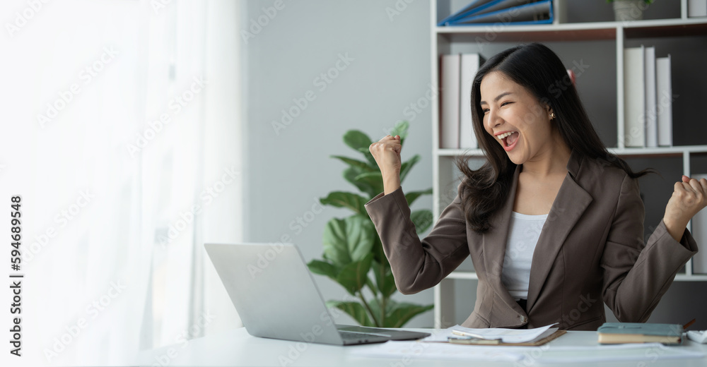 Copy space, panorama, banner, Asian business woman Online freelancers are making a happy gesture. to know the results of financial approval Business cooperation agreement on laptop computer in office Copy space, panorama, banner, Asian business woman Online freelancers are making a happy gesture. to know the results of financial approval Business cooperation agreement on laptop computer in office
