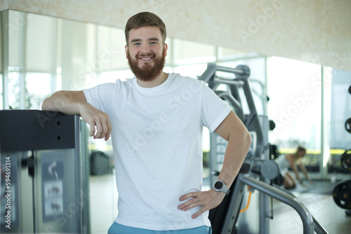 Portrait of fit athletic young bearded man in gym, fitness trainer, coach.