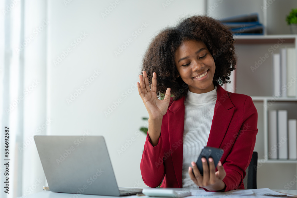 African american businesswoman working with laptop computer delighted with positive feedback on real estate project chatting online via mobile app sharing good news to colleague approved job.