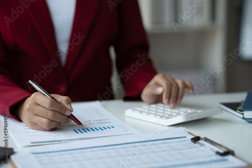 businesswoman, investor using calculator to calculate income tax and income, finance accounting, database from graph office real estate business statistics.
