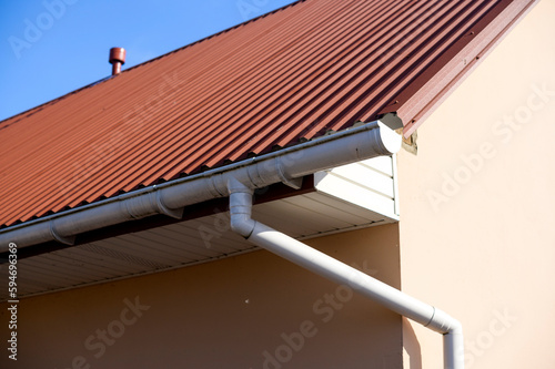 roof corner of a building with metal slate and gutter rainwater