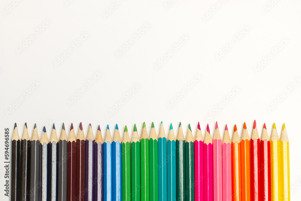 Lápices de colores en fila sobre un fondo blanco liso y aislado. Vista superior y de cerca. Copy space Lápices de colores en fila sobre un fondo blanco liso y aislado. Vista superior y de cerca. Copy space