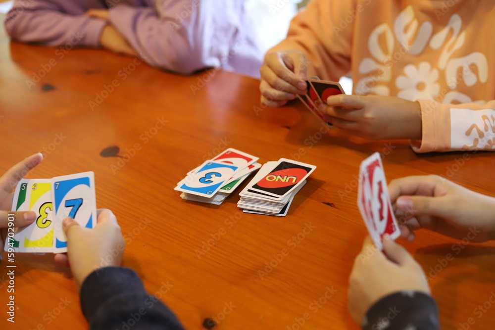 Group of children playing cards. Boys playing card game UNO. Board game. Teenagers having fun
