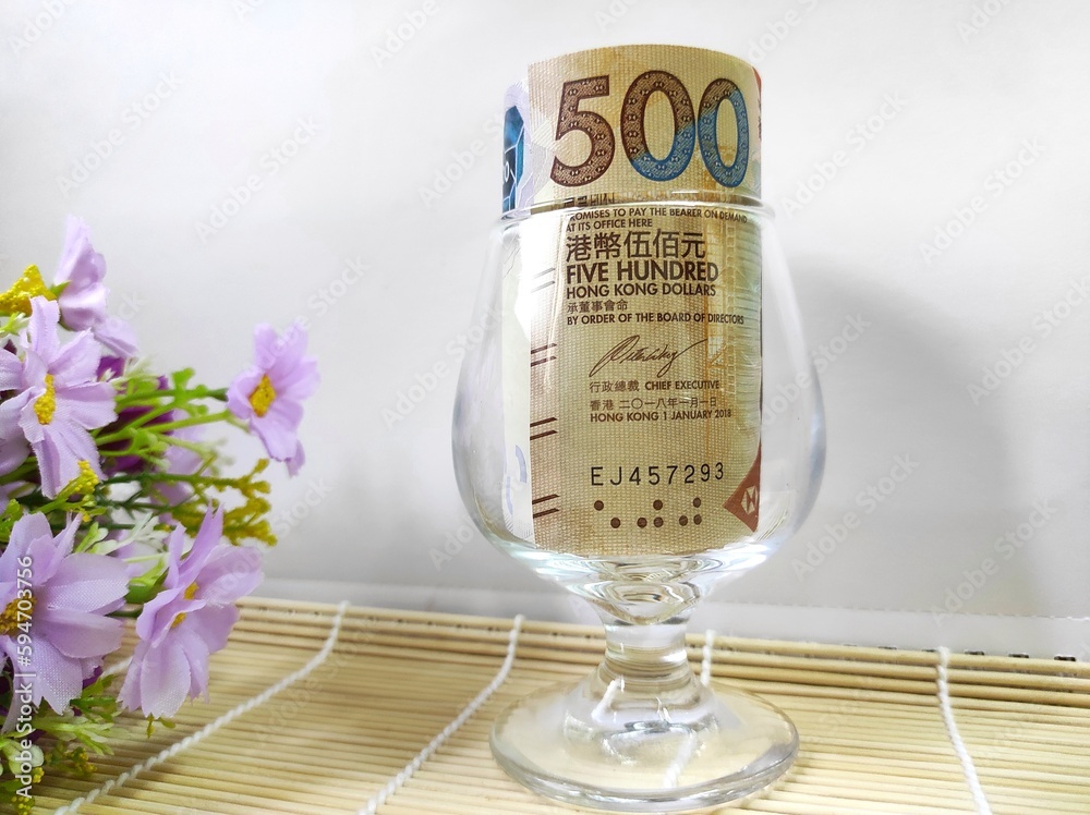 500-hong-kong-dollar-bill-rolled-in-transparent-glass-with-white