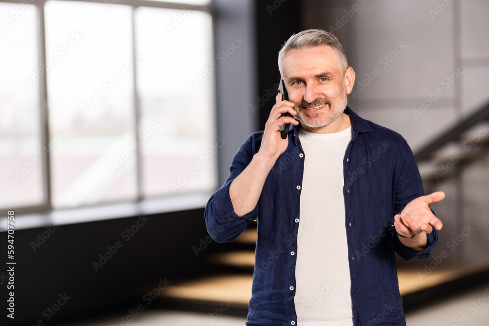 Happy elder grandfather talking on mobile phone, resting on comfortable sofa, speaking, smiling, laughing, chatting, contact family. Happy elder grandfather talking on mobile phone, resting on comfortable sofa, speaking, smiling, laughing, chatting, contact family.