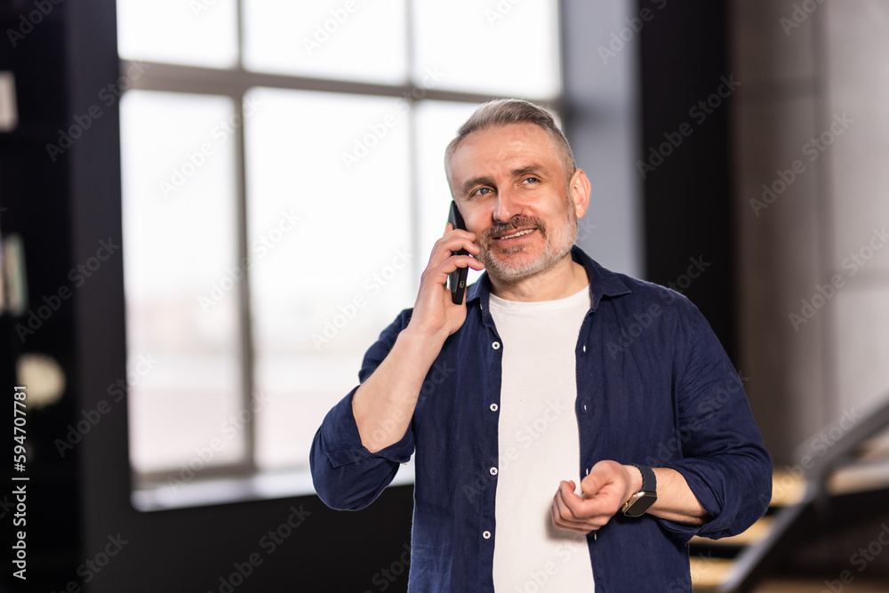 Happy elder grandfather talking on mobile phone, resting on comfortable sofa, speaking, smiling, laughing, chatting, contact family. Happy elder grandfather talking on mobile phone, resting on comfortable sofa, speaking, smiling, laughing, chatting, contact family.
