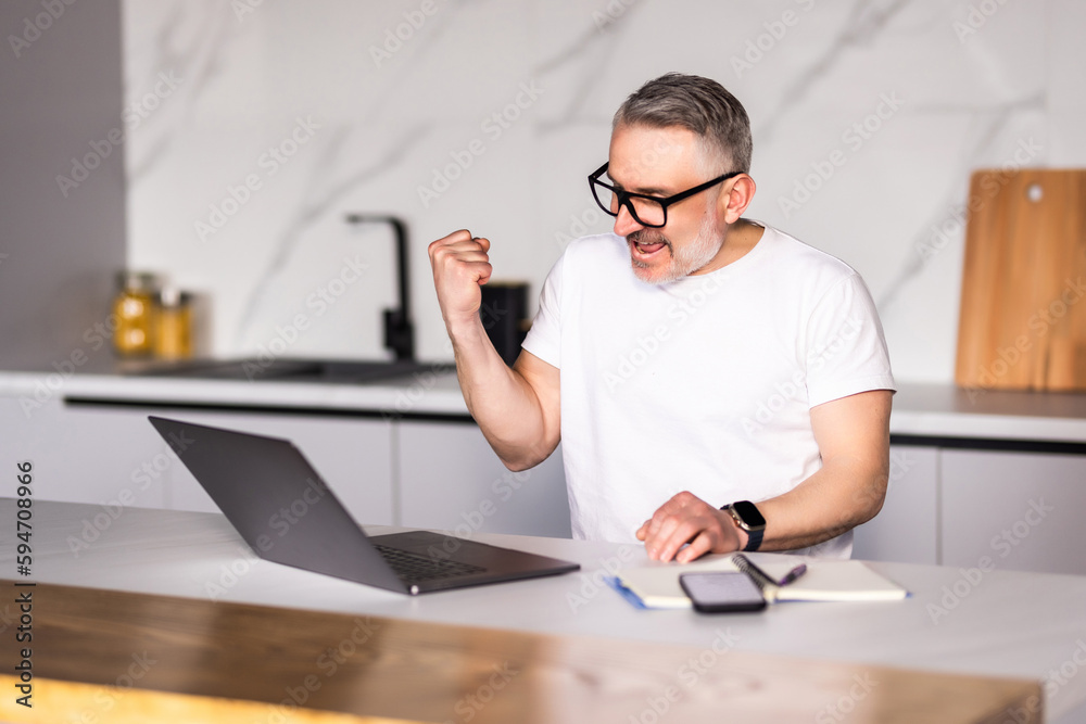 Middle age handsome businessman wearing tie sitting using laptop at the office celebrating surprised and amazed for success with arms raised and open eyes. Winner concept. Middle age handsome businessman wearing tie sitting using laptop at the office celebrating surprised and amazed for success with arms raised and open eyes. Winner concept.