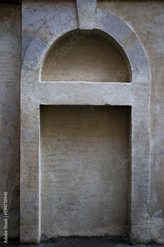 Fotografiet Vertical shot of an arched stone niche situated on a corner wall of a street