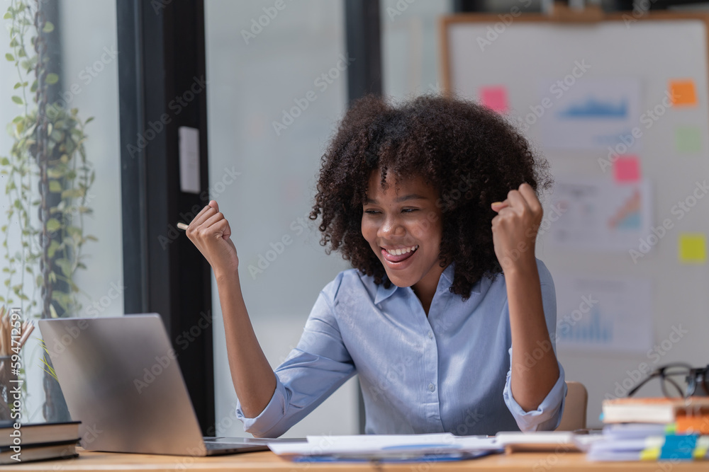 Female Entrepreneur. Cheerful African American Businesswoman Working On document and Laptop In Modern Office. Empty Space Female Entrepreneur. Cheerful African American Businesswoman Working On document and Laptop In Modern Office. Empty Space