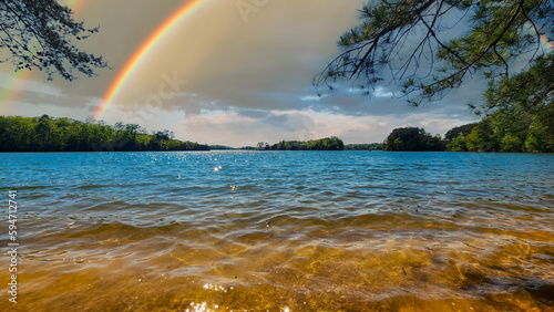 a gorgeous spring landscape at Lanier Point Park with rippling blue water surrounded by lush green trees and plants with blue sky, clouds and a rainbow at Lake Lanier in Gainesville Georgia USA photo