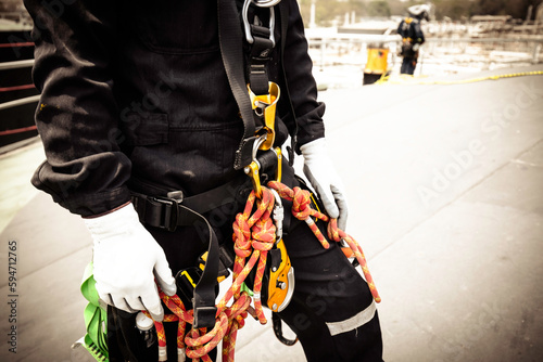 Closeup male worker standing on tank male worker height roof tank knot carabiner rope access safety