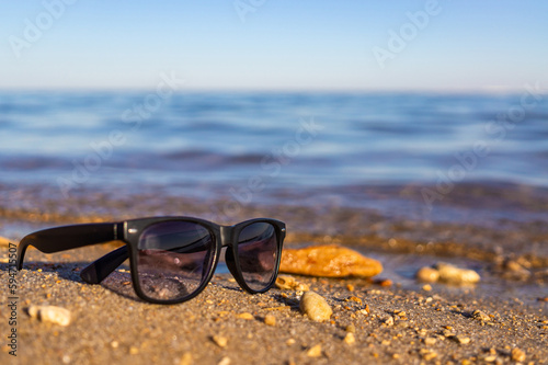 Sunglasses on the sand beach in the sunset