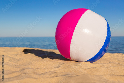 Beach ball on the sand beach on the blue sea