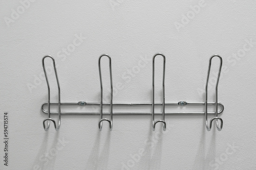 Metal hangers on the white wall close up