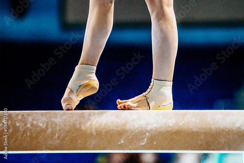 close-up legs female gymnast step on balance beam in gymnastics, fitted neoprene ankle support with heel cup photo