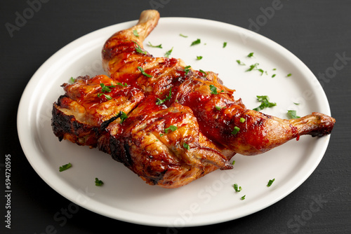 Homemade Spatchcocked Grilled Piri-Piri Chicken with Parsley on a Plate, side view.