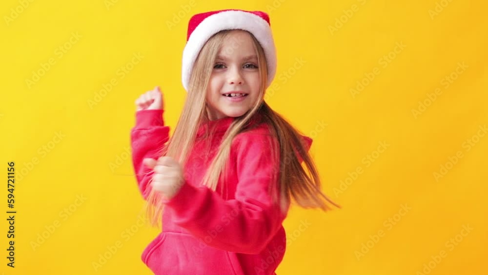 portrait of a little girl in a santa hat on a yellow background portrait of a little girl in a santa hat on a yellow background