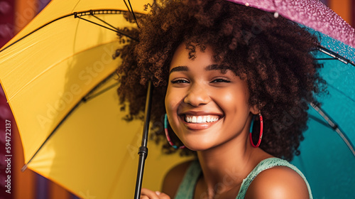 Smiling afro young woman with colorful umbrella. Summertime concept.