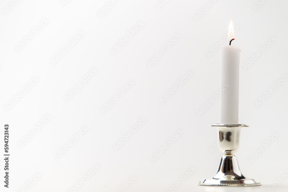 burning candle inside silver candlestick on a white background steel metallic lamp flame burning candle inside silver candlestick on a white background steel metallic lamp flame