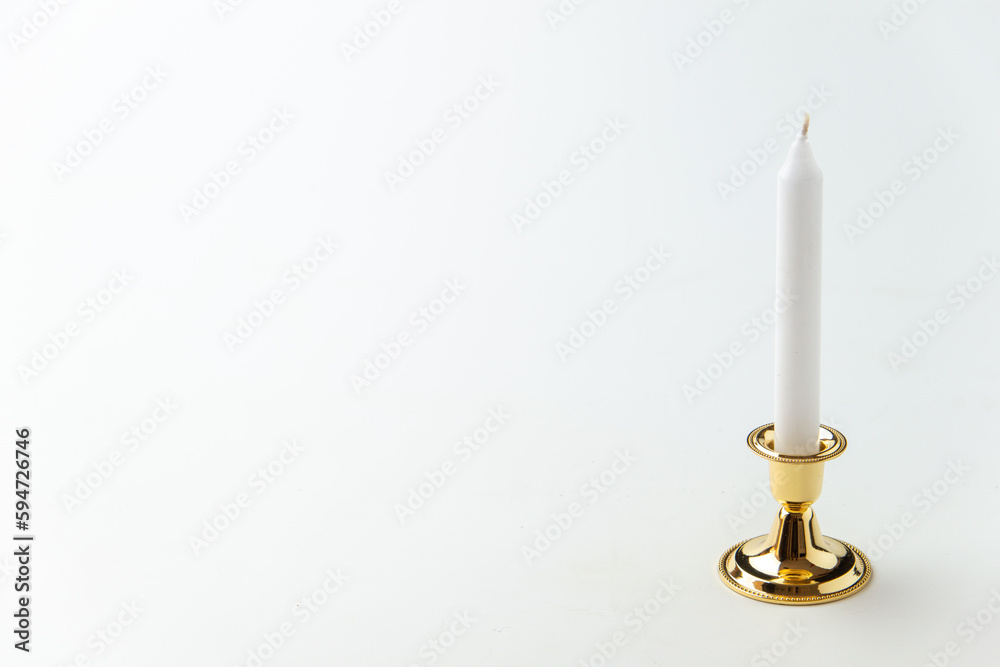 white candle inside golden candlestick on the white background flame lamp steel metallic fire white candle inside golden candlestick on the white background flame lamp steel metallic fire