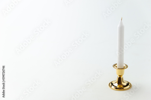 white candle inside golden candlestick on the white background flame lamp steel metallic fire