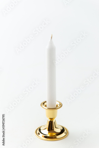 white candle inside golden candlestick on white background flame lamp fire steel metallic