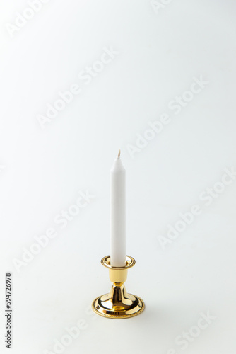 white candle inside golden candlestick on white background flame lamp steel metallic fire
