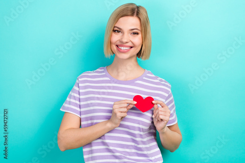 Portrait of nice friendly funny woman with stylish hairdo dressed striped t-shirt hold postcard on heart isolated on teal color background