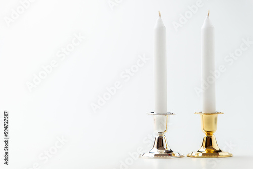 white candles inside elegant candlesticks on white background lamp fire steel metallic