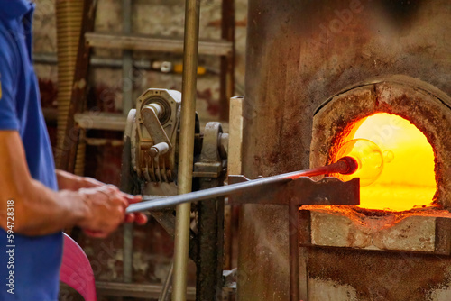 Glass Blower Shaping Molten Glass into a Piece of Art photo