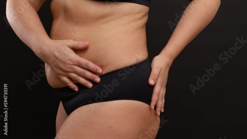 Wallpaper Mural Unrecognizable plump woman wearing black seamless sportswear, adjusting trying on black sports panties, stand on black background, turning side on. Overweight, body positive, weight loss, underwear. Torontodigital.ca