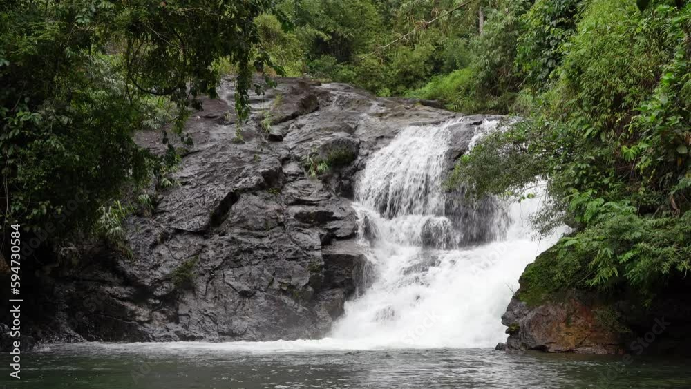 Scenic view of Khlong Chao Waterfall surrounded by tropical trees, Koh Kood, Thailand Scenic view of Khlong Chao Waterfall surrounded by tropical trees, Koh Kood, Thailand