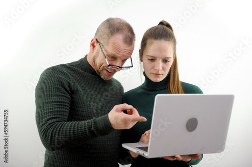 Professional teacher, manager or mentor helping latin student, new employee, teaching intern, explaining online job using laptop computer, talking, having teamwork discussion in office. High quality