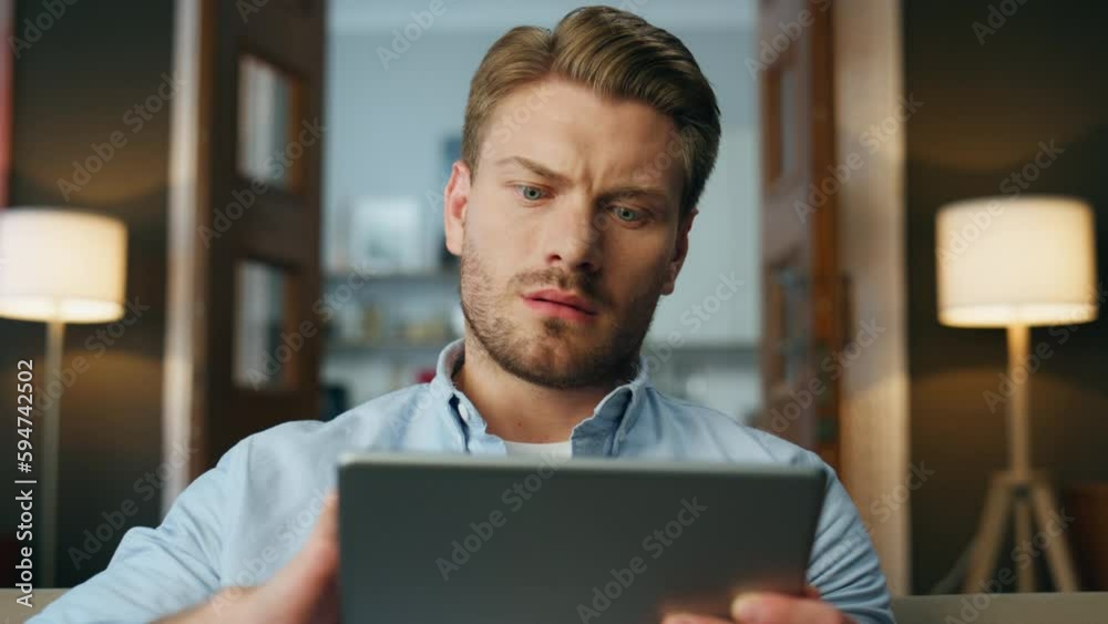 Focused man reading pad computer zoom out. Serious businessman zooming screen Focused man reading pad computer zoom out. Serious businessman zooming screen